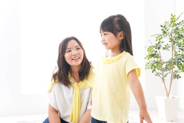 Anne çocuğuyla oynuyor, anne ve kızı birlikte vakit geçiriyorlar.