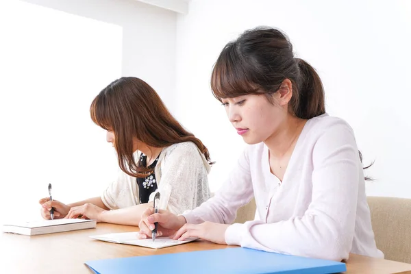 机で勉強している2人の女子学生が — ストック写真