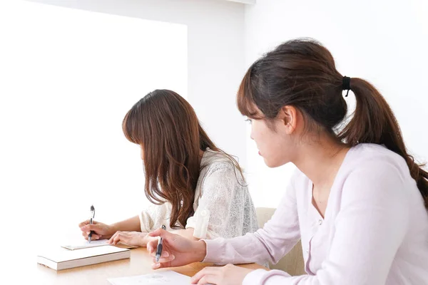 机で勉強している2人の女子学生が — ストック写真