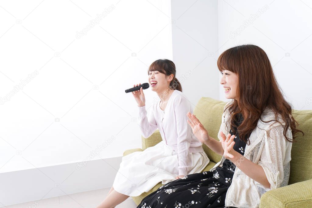friends enjoying karaoke on couch