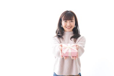 Takım elbiseli genç bir kadın beyaz arka planda hediye kutusu tutuyor.,