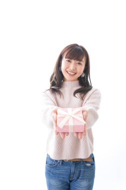 Takım elbiseli genç bir kadın beyaz arka planda hediye kutusu tutuyor.,