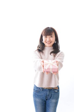 Takım elbiseli genç bir kadın beyaz arka planda hediye kutusu tutuyor.,