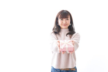 Takım elbiseli genç bir kadın beyaz arka planda hediye kutusu tutuyor.,