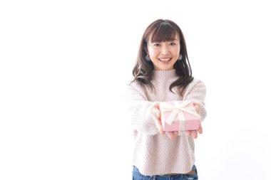 Takım elbiseli genç bir kadın beyaz arka planda hediye kutusu tutuyor.,