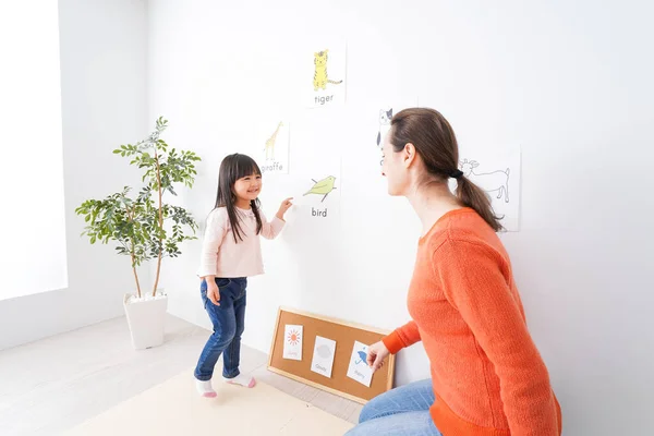 little girl studying English with teacher