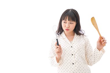 Arka planda yemek yapan genç bir kadın.