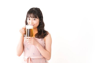 Genç Asyalı kadın evde bira içiyor.