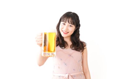 Genç Asyalı kadın evde bira içiyor.