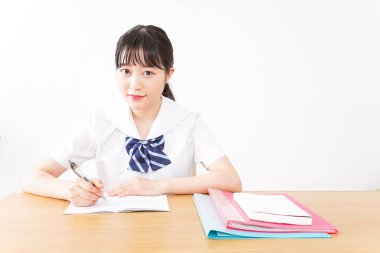 young Asian female student in uniform studying  clipart