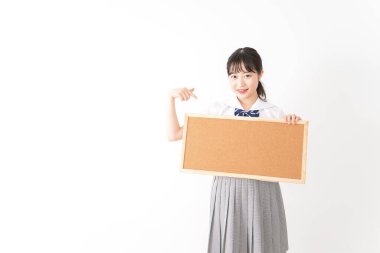 Genç Asyalı bir kız öğrenci elinde bir pano tutuyor.