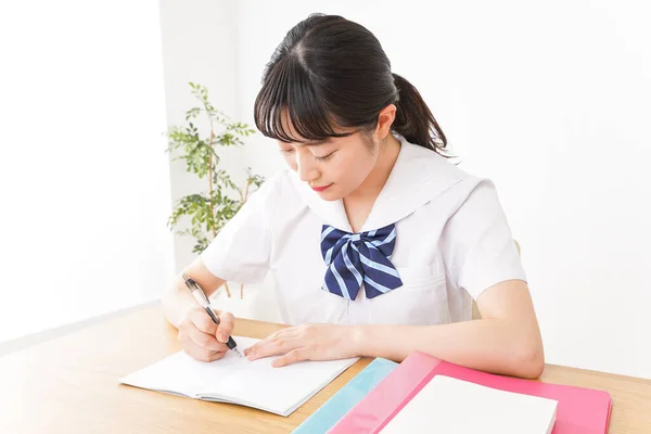 young Asian female student in uniform studying