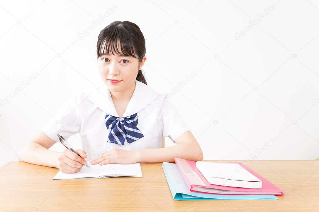 young Asian female student in uniform studying 
