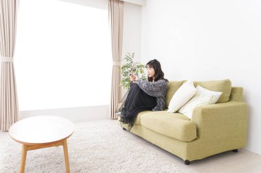 Evde televizyon izleyen genç bir kadın.