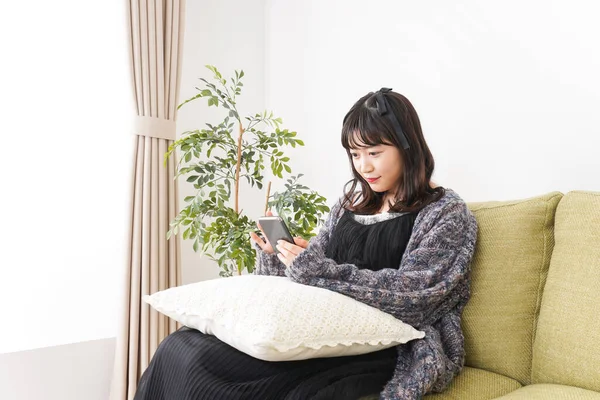 Young Woman Uses Smartphone Home — Stock Photo, Image