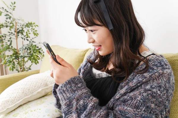 Young Woman Uses Smartphone Home — Stock Photo, Image