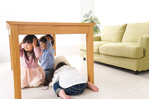桌子下的孩子们 从地震中疏散 — 图库照片