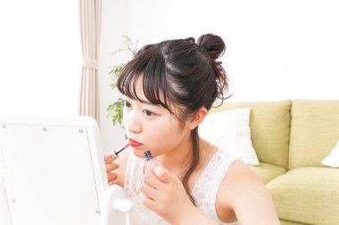 Makyaj yapan genç bir kadın.