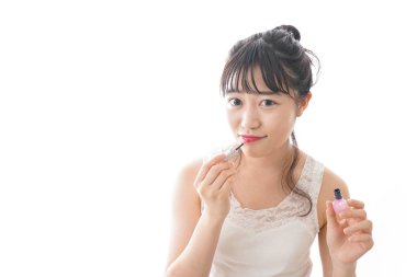 Makyaj yapan genç bir kadın.