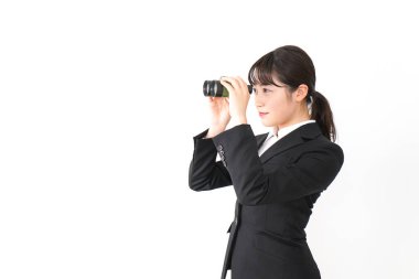 Beyaz arka planda dürbünü olan genç bir kadın. 