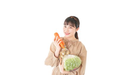 Beyaz arka planda sebzeli genç bir kadın.