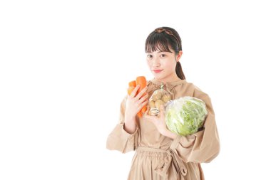 Beyaz arka planda sebzeli genç bir kadın.