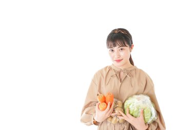 Beyaz arka planda sebzeli genç bir kadın.