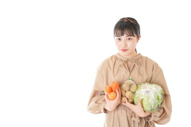 Beyaz arka planda sebzeli genç bir kadın.