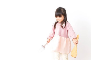 Mutfakta yemek pişiren tatlı küçük kız.