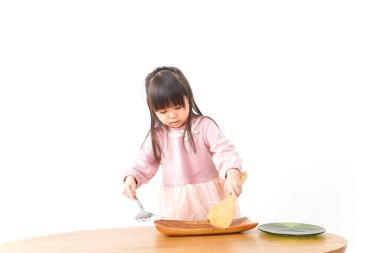 Mutfakta yemek pişiren tatlı küçük kız.