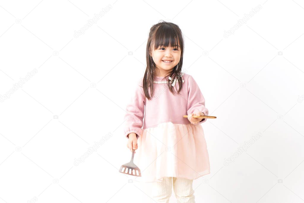 Cute little girl cooking at kitchen