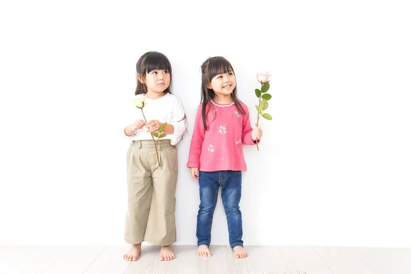 Beyaz Arka Planda Izole Edilmiş Çiçeklerle Poz Veren Küçük Kızlar — Stok fotoğraf