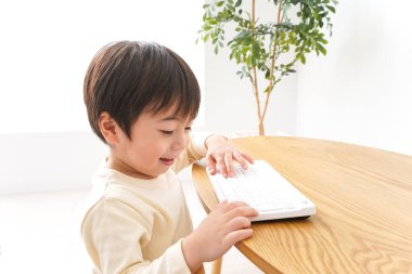 Küçük Asyalı çocuk klavye kullanıyor 