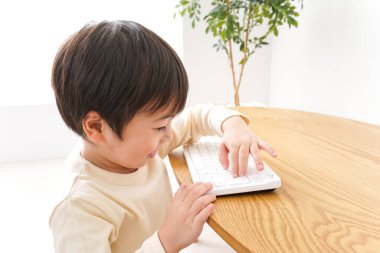 Küçük Asyalı çocuk klavye kullanıyor 