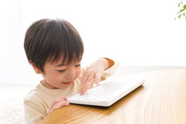 Küçük Asyalı çocuk klavye kullanıyor 