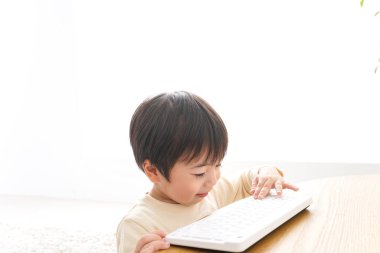 Küçük Asyalı çocuk klavye kullanıyor 