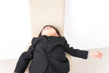 Siyah takım elbiseli küçük Asyalı çocuk