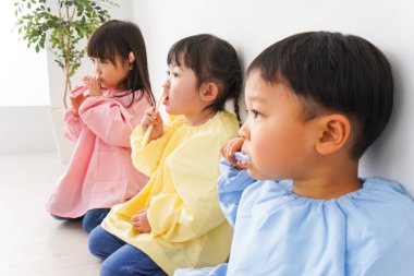 Çocuklar dişlerini fırçalıyorlar.