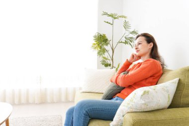 Evde televizyon izleyen genç bir kadın.