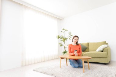 Genç bayan evde kahve içiyor.