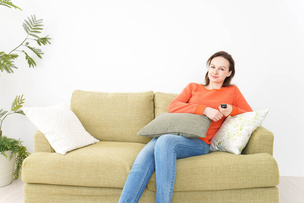 Молодая женщина смотрит телевизор дома