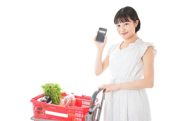 Junge Frau Mit Vollem Einkaufswagen Und Taschenrechner — Stockfoto