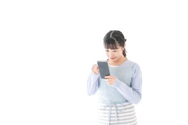 Gülümseyen akıllı telefon kullanan genç bir kadın.