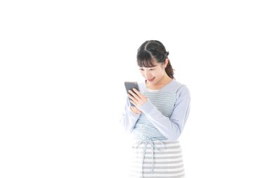 Gülümseyen akıllı telefon kullanan genç bir kadın.