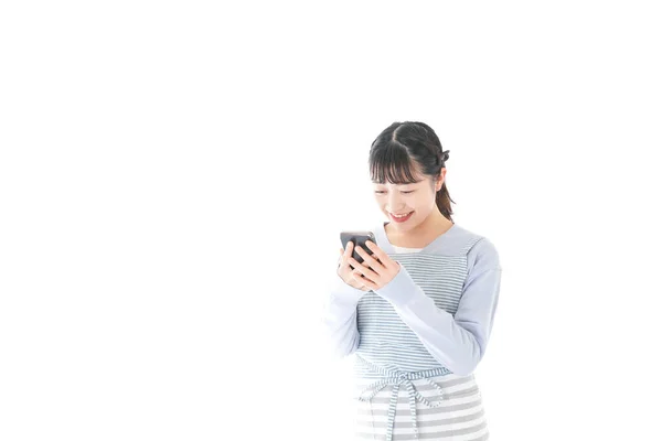 笑顔でスマホを使う若い女性 — ストック写真