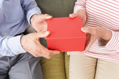  Son sınıf çifti kırmızı kutuyu bir arada tutuyor. 