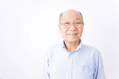 Kıdemli adam beyaz arka planda gülümsüyor.