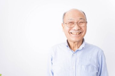 Kıdemli adam beyaz arka planda gülümsüyor.