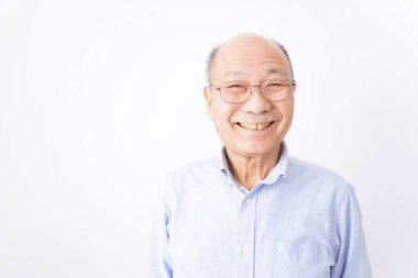 Kıdemli adam beyaz arka planda gülümsüyor.