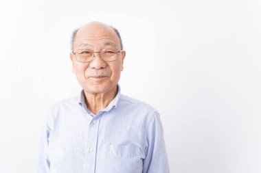 Kıdemli adam beyaz arka planda gülümsüyor.